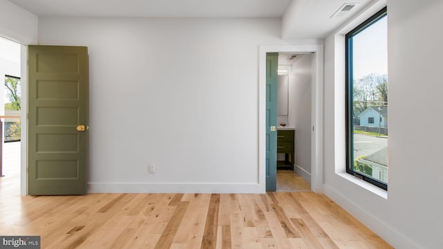 unfurnished room featuring baseboards, visible vents, and light wood finished floors