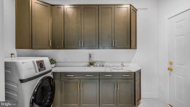 laundry room featuring light tile patterned flooring, washer and dryer, and cabinet space