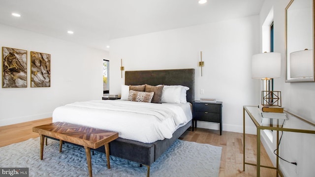 bedroom with recessed lighting, wood finished floors, and baseboards