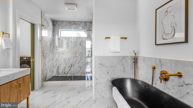 bathroom featuring marble finish floor, vanity, a marble finish shower, wainscoting, and a freestanding tub