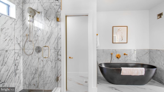 full bathroom with a soaking tub, tile walls, a marble finish shower, and marble finish floor