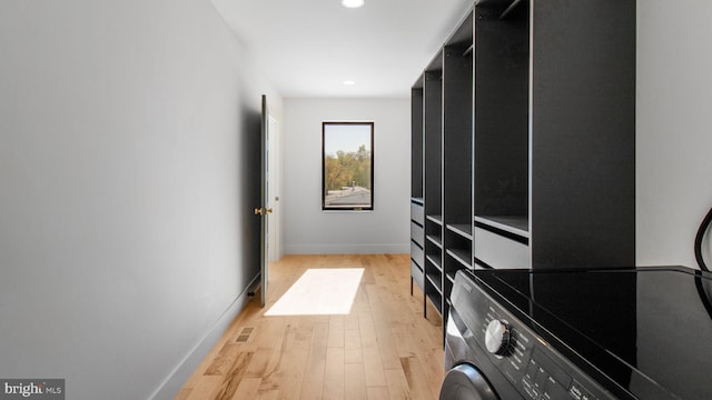 clothes washing area featuring washer / dryer, light wood finished floors, baseboards, laundry area, and recessed lighting