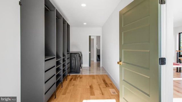 hall featuring light wood-type flooring, baseboards, recessed lighting, and visible vents