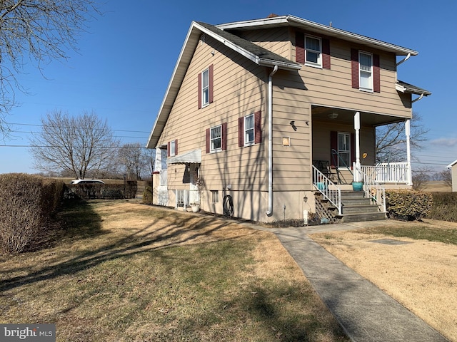 view of front of house with covered porch and a front lawn