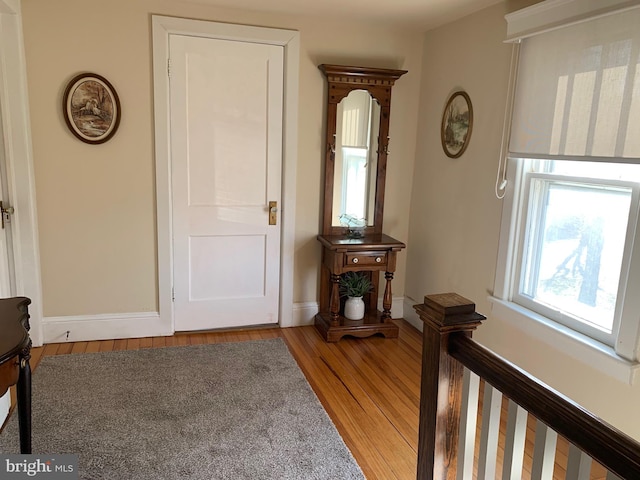 hallway featuring light wood-style flooring and baseboards