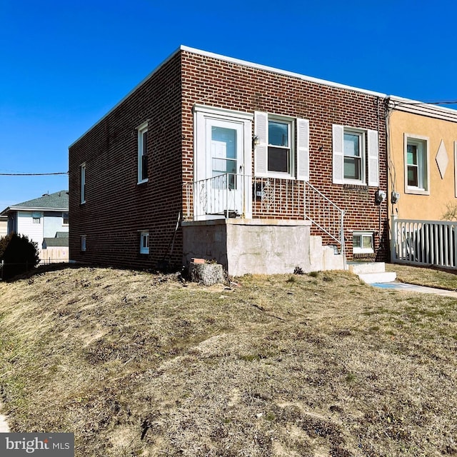 view of front of house with brick siding and a front lawn