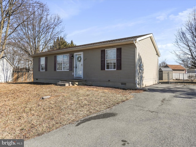 ranch-style house featuring aphalt driveway, crawl space, and fence