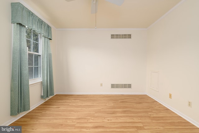 unfurnished room featuring light wood-style flooring, visible vents, and ornamental molding