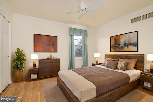 bedroom featuring light wood finished floors, crown molding, and ceiling fan