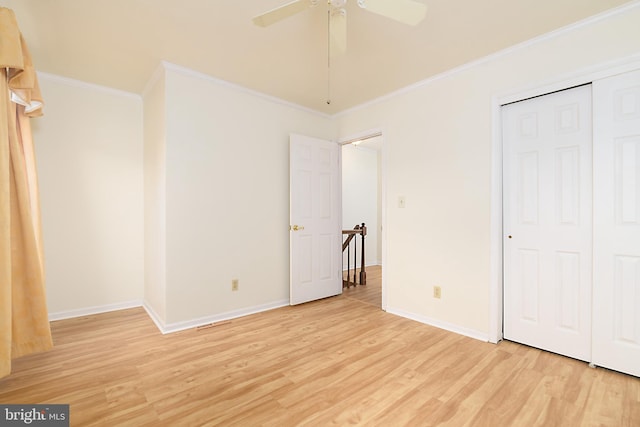 unfurnished bedroom featuring light wood finished floors, a closet, baseboards, and ornamental molding