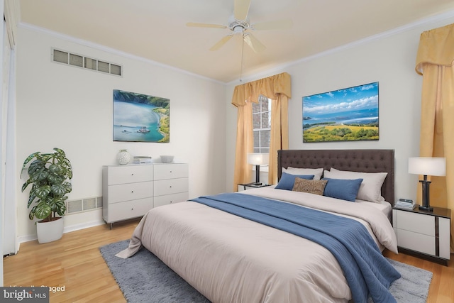 bedroom with crown molding, light wood-style floors, and visible vents