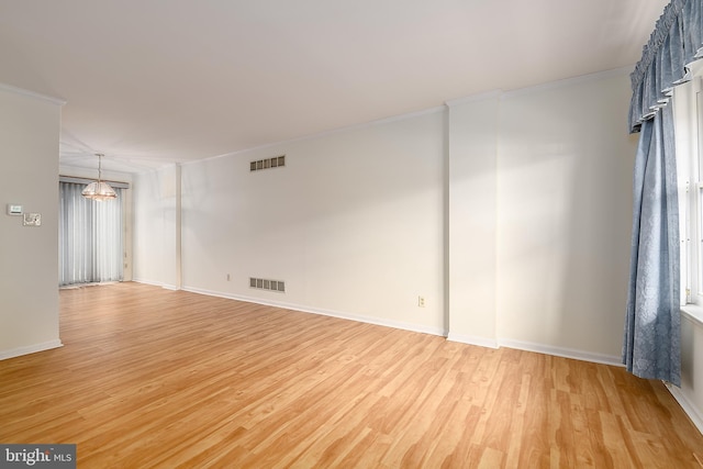 spare room with baseboards, visible vents, a chandelier, and light wood-type flooring