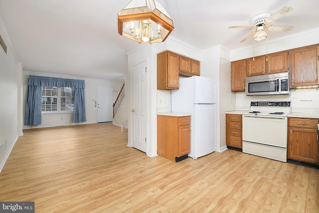 kitchen with white appliances, light countertops, light wood-style floors, and ornamental molding