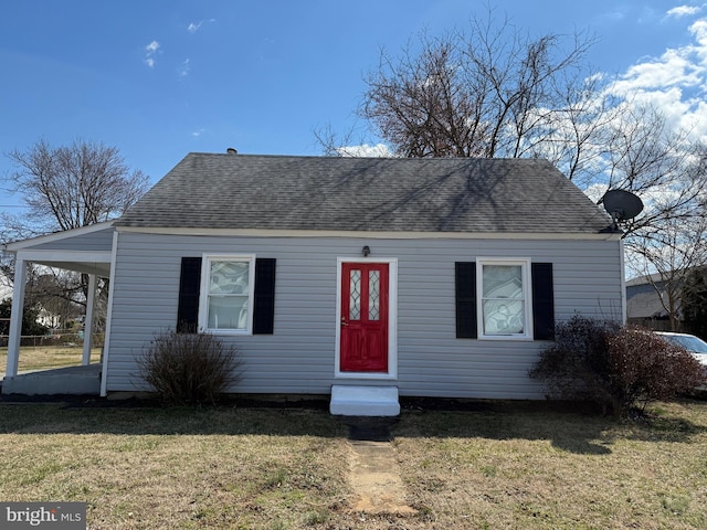 view of front facade featuring roof with shingles and a front yard