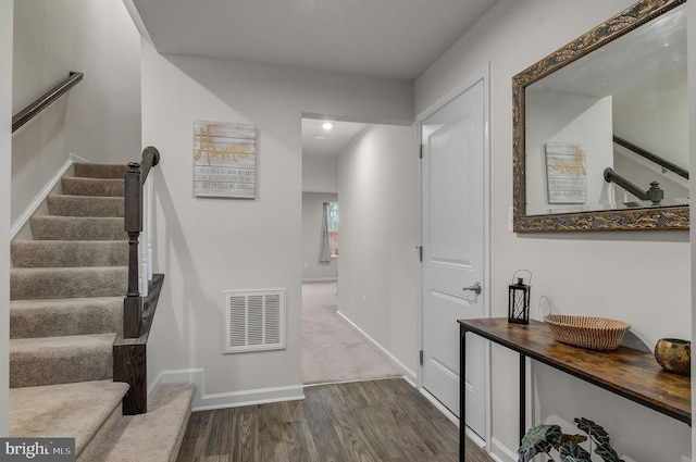 staircase featuring visible vents, baseboards, and wood finished floors