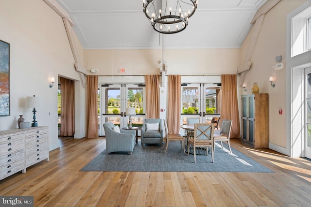 dining area featuring wood-type flooring, a high ceiling, a wealth of natural light, and french doors