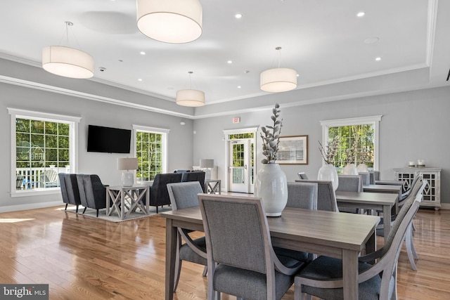 dining space featuring a tray ceiling, light wood-type flooring, recessed lighting, and crown molding