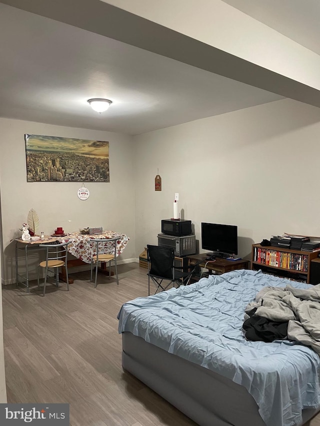 bedroom with baseboards and wood finished floors