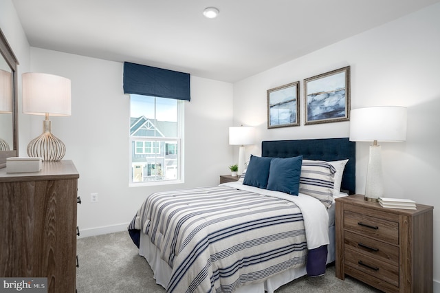 bedroom featuring light colored carpet and baseboards