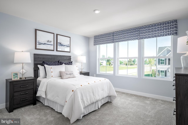 bedroom featuring light carpet and baseboards