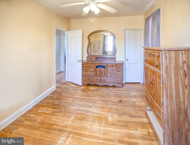 unfurnished bedroom featuring ceiling fan, baseboards, and light wood-style floors