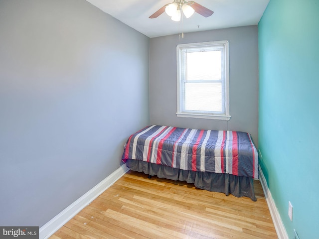 bedroom with a ceiling fan, baseboards, and wood finished floors