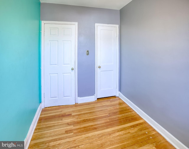 unfurnished bedroom featuring baseboards and light wood finished floors