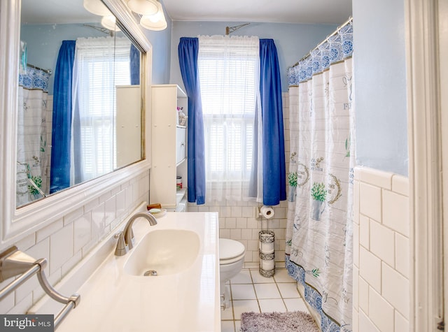 bathroom featuring tile patterned floors, toilet, tile walls, and vanity