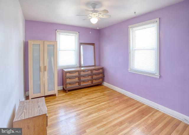 unfurnished room with baseboards, light wood-style floors, and ceiling fan