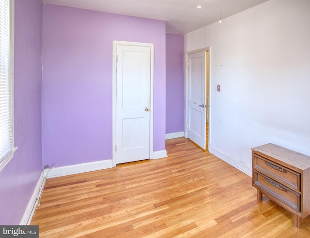 unfurnished bedroom with baseboards and light wood-style floors