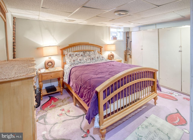 bedroom with a drop ceiling and a closet