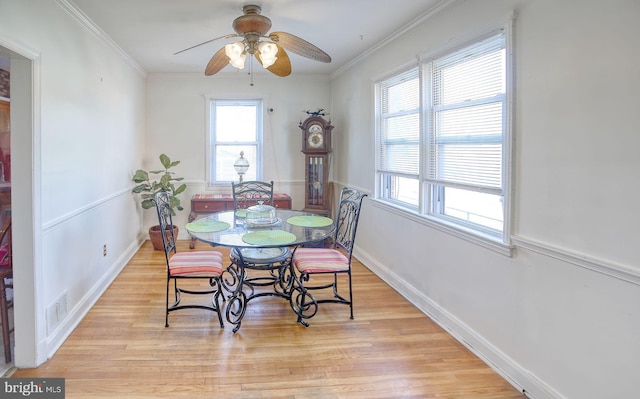 dining space featuring baseboards, light wood-style floors, visible vents, and ornamental molding