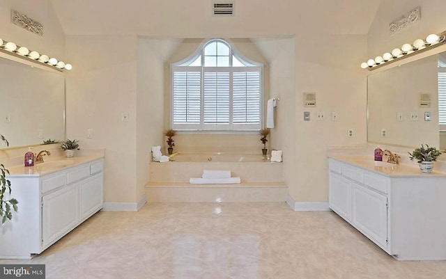 bathroom with two vanities, a garden tub, a sink, and visible vents