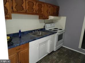 kitchen with brown cabinetry, dark countertops, white electric range, and a sink