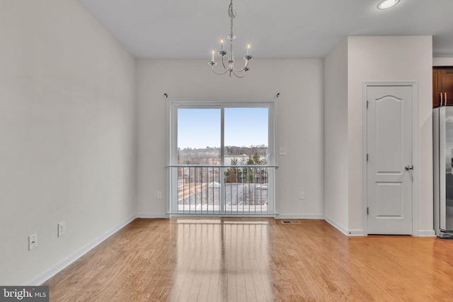 interior space with light wood-type flooring, baseboards, and a chandelier