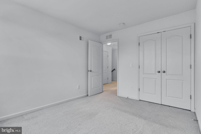 unfurnished bedroom with a closet, visible vents, baseboards, and carpet flooring