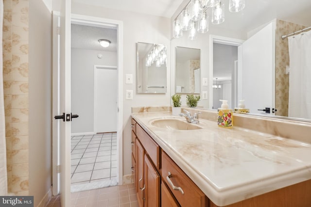 full bathroom featuring tile patterned floors, baseboards, a textured ceiling, and vanity