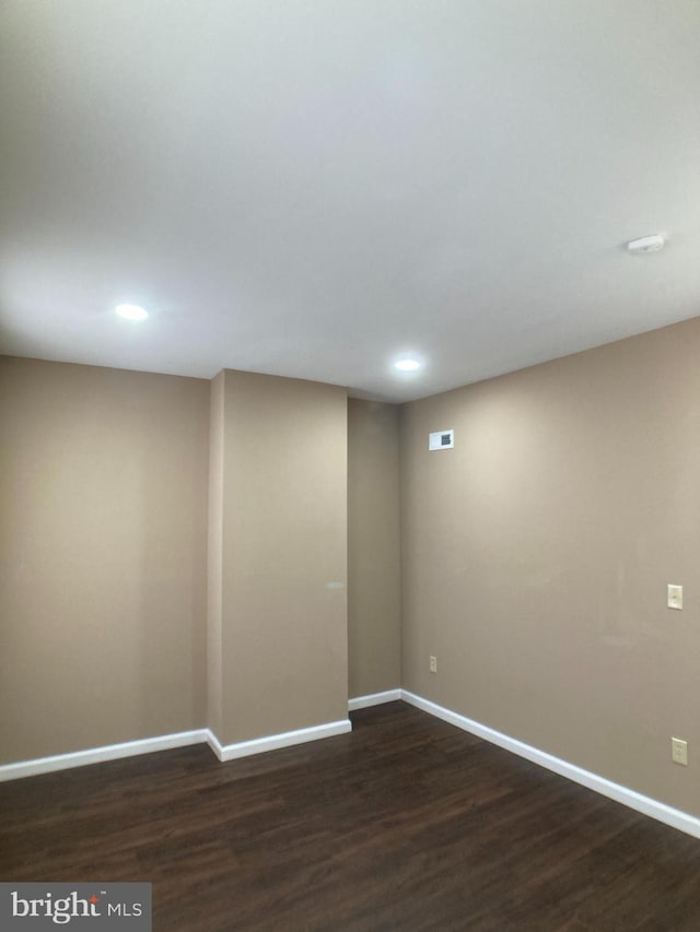 interior space with dark wood-type flooring, visible vents, and baseboards