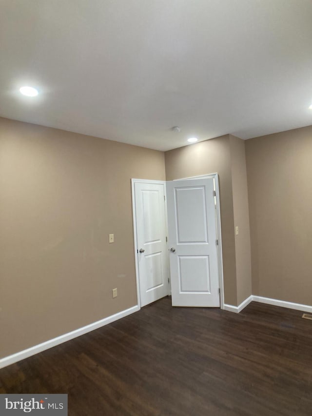 unfurnished room featuring dark wood-style floors, recessed lighting, and baseboards