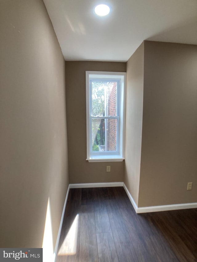 empty room with dark wood-style floors and baseboards