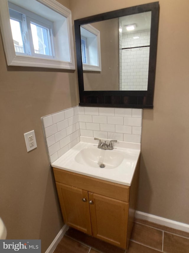 bathroom with baseboards, backsplash, and vanity