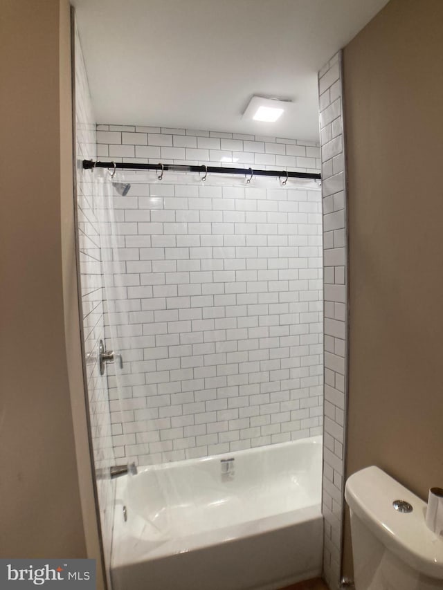 bathroom featuring shower / bath combination and toilet