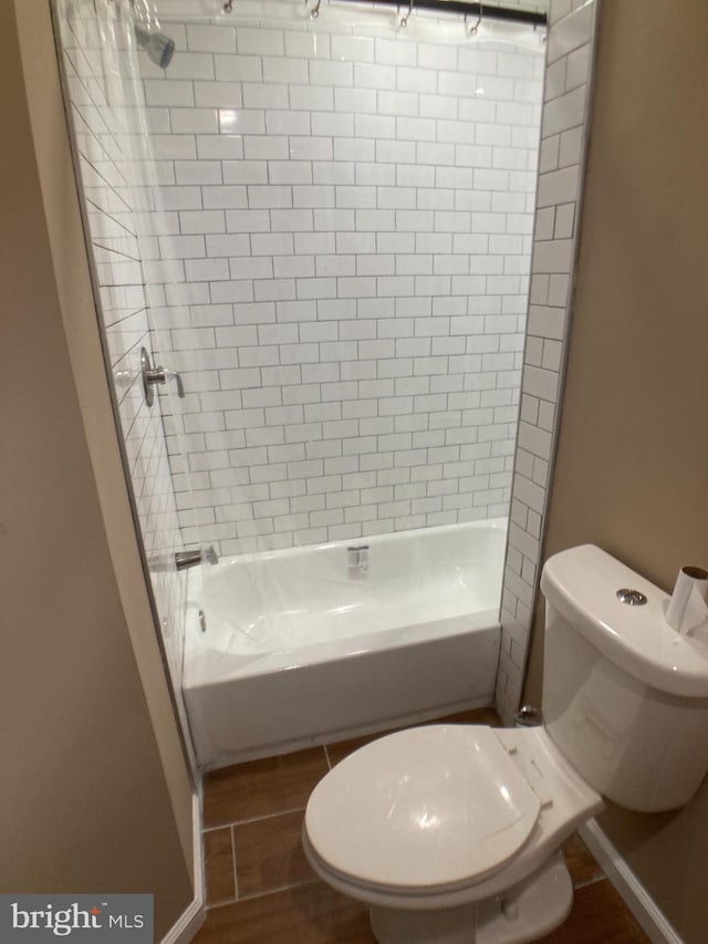 bathroom featuring  shower combination, wood tiled floor, and toilet