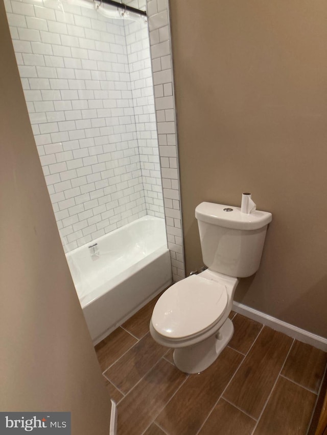 full bath with  shower combination, wood tiled floor, baseboards, and toilet