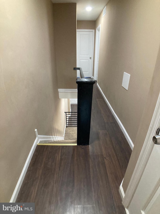 staircase featuring wood finished floors, visible vents, and baseboards