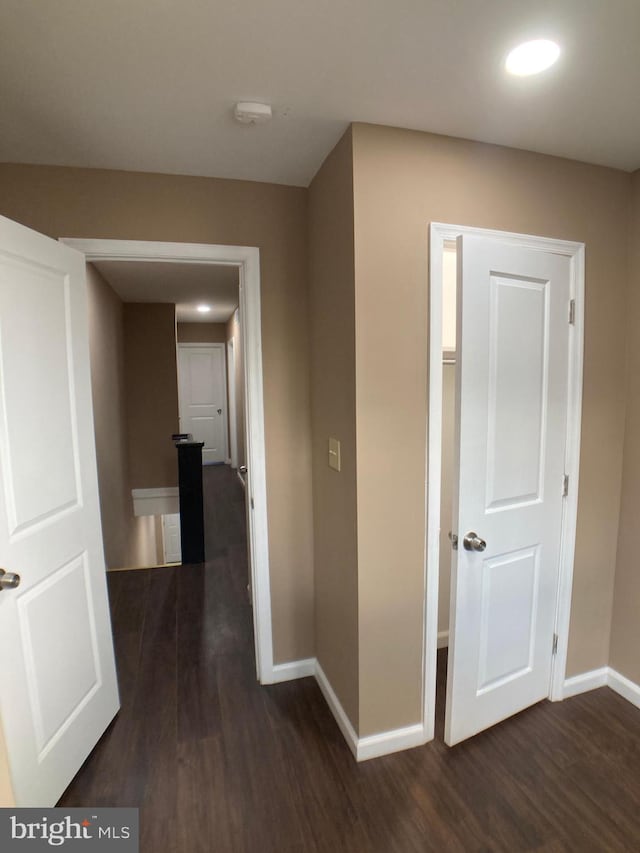 corridor featuring dark wood-style floors and baseboards