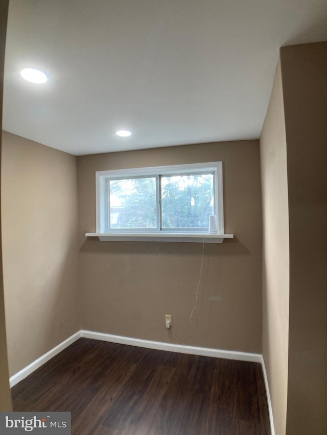 empty room featuring dark wood-style flooring, recessed lighting, and baseboards