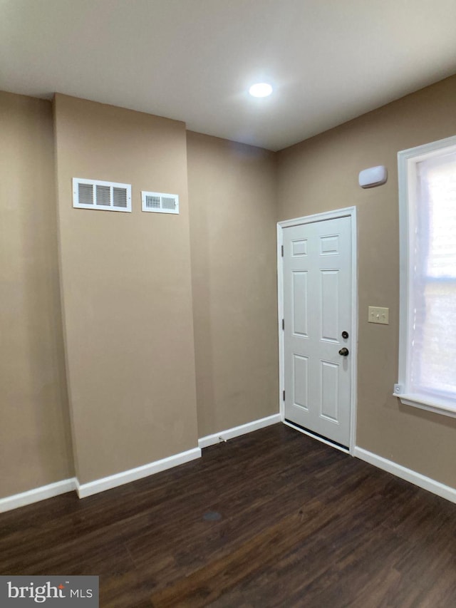 entryway featuring dark wood-type flooring, plenty of natural light, visible vents, and baseboards