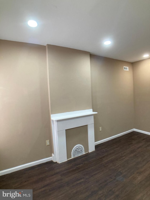 unfurnished living room featuring dark wood-style floors, a fireplace, and baseboards