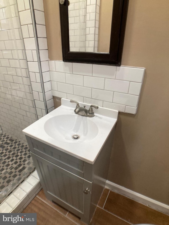 bathroom with tile walls, vanity, decorative backsplash, and wood finished floors